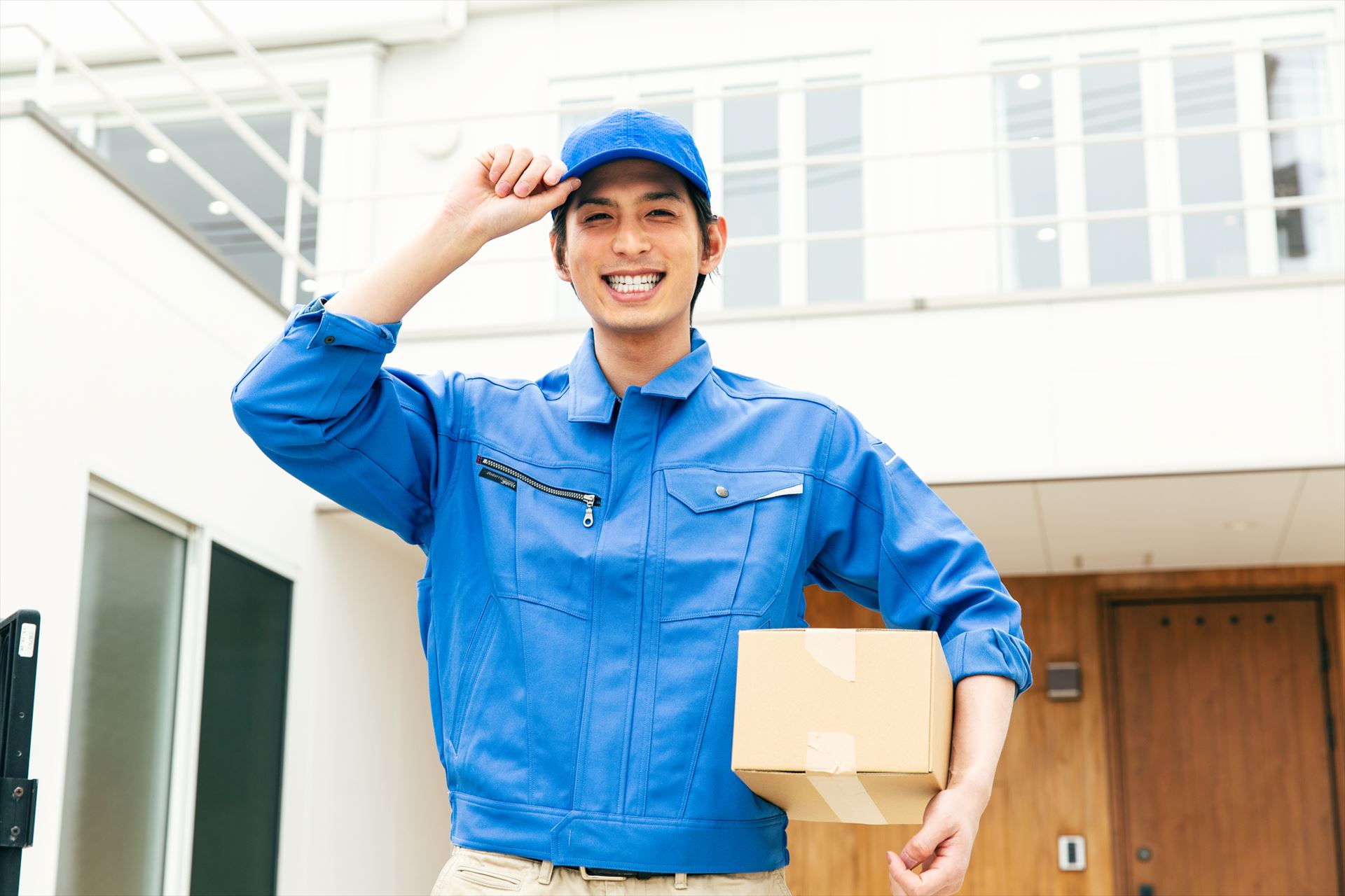 マンションで荷物を配達する男性スタッフ